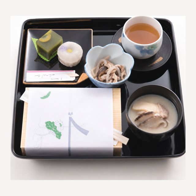 法事の配膳例。漆器の膳にお茶・和菓子・お吸い物・折詰を配したおもてなしの御膳