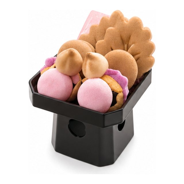 赤の盛菓子。桃色の落雁や焼き菓子を脚付きの供物台に高く盛り付けた、ウワイスーコー（お祝いの法事）用のお供え菓子